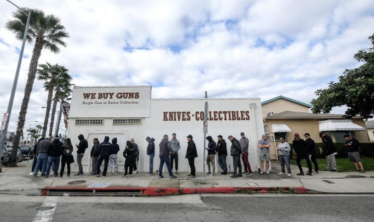 People wait in line to enter a gun store in Culver City, Calif., on Sunday. Coronavirus concerns have led to consumer panic buying of grocery staples, and now gun stores are seeing a similar run on weapons and ammunition.