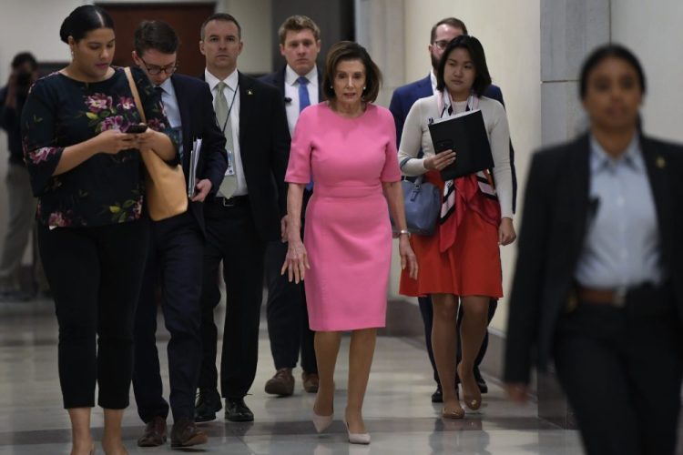 House Speaker Nancy Pelosi of Calif., heads to a news conference on Capitol Hill in Washington on Thursday. Pelosi said the House is expected to pass the massive coronavirus aid package with bipartisan support on Friday. 