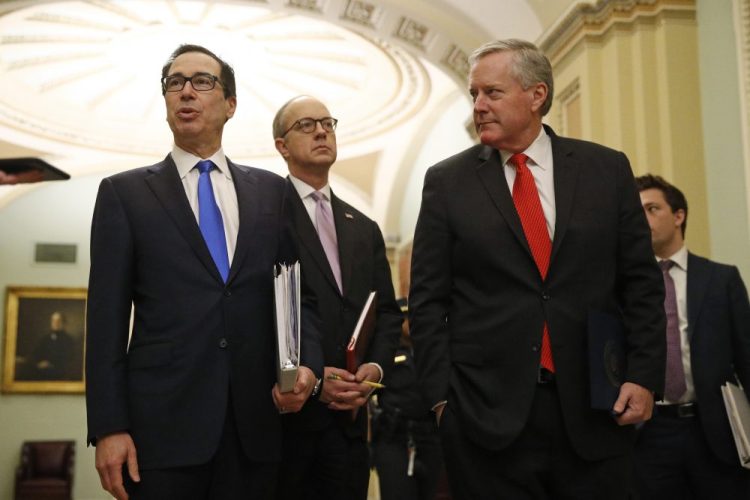 Treasury Secretary Steven Mnuchin, left, accompanied by White House Legislative Affairs Director Eric Ueland and acting White House chief of staff Mark Meadows, speaks with reporters as he walks to the offices of Senate Majority Leader Mitch McConnell of Kentucky on Capitol Hill in Washington on Tuesday.