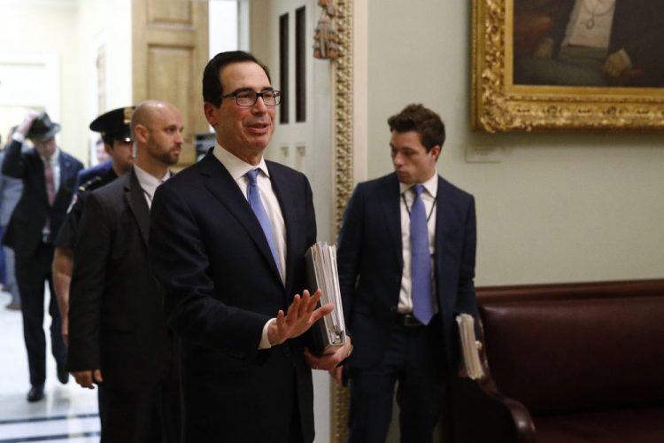 Treasury Secretary Steve Mnuchin asks members of the media to practice social distancing as he departs a meeting on Capitol Hill in Washington on Monday. Mnuchin said Thursday that a current proposal would pay each American adult $1,000 and each child $500 in an effort to deal with the economic fallout of the coronavirus pandemic.