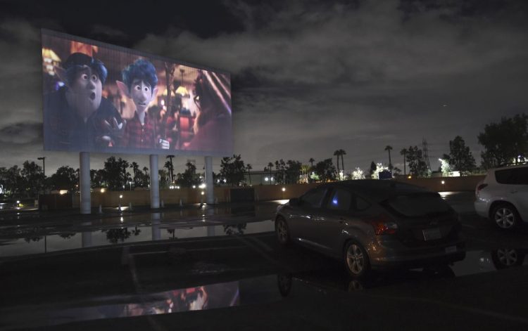 Viewers in a parked car watch the animated film "Onward" on Thursday at the Paramount Drive-In Theatres in Paramount, Calif. 