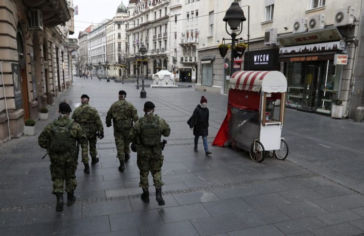 Serbian army soldiers patrol Thursday in Belgrade's main pedestrian street. Since declaring a  nationwide state of emergency Serbian President Aleksandar Vucic has suspended parliament, giving him widespread powers, such as closing borders and introducing a 12-hour curfew. 
