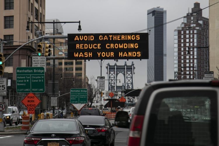 A flashing sign urges commuters headed for the Manhattan bridge  to avoid gatherings, reduce crowding and to wash hands in the Brooklyn borough of New York. 