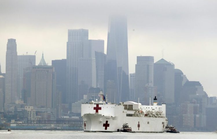 The Navy hospital ship USNS Comfort passes lower Manhattan on its way to docking in New York on Monday. The ship has 1,000 beds and 12 operating rooms that could be up and running within 24 hours of its arrival on Monday morning. It's expected to bolster a besieged health care system by treating non-coronavirus patients while hospitals treat people with COVID-19.