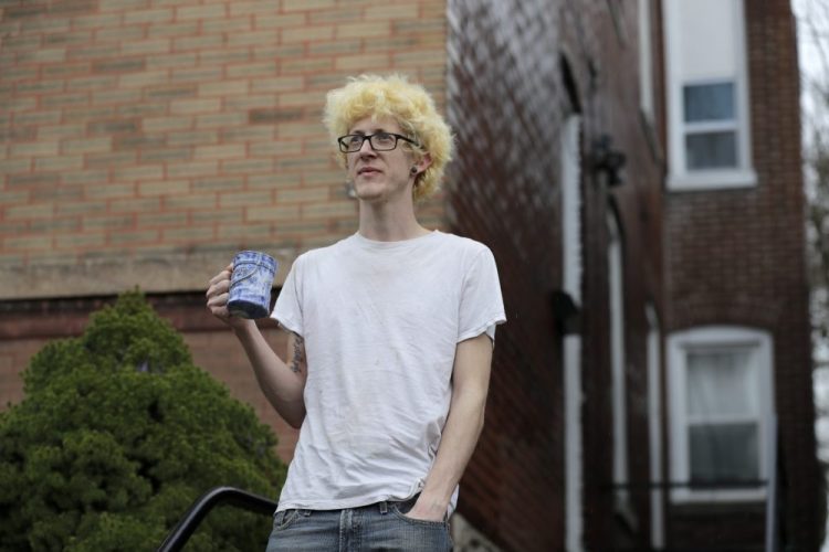 Kyle Kofron, shown Saturday outside his home in St. Louis, still has his job at an ice cream factory, but his three roommates are suddenly unemployed due the the pandemic. Kofron is advocating for a rent strike during the outbreak, saying it may be their only option. 
