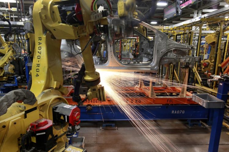 Robots weld a Chevrolet Sonic at the General Motors Orion Assembly plant May 19, 2011, in Orion Township, Mich. General Motors, Ford, jet engine maker Rolls-Royce and other companies are talking to their governments about repurposing idled factories to produce vital goods to fight the coronavirus such as ventilators and surgical masks. 