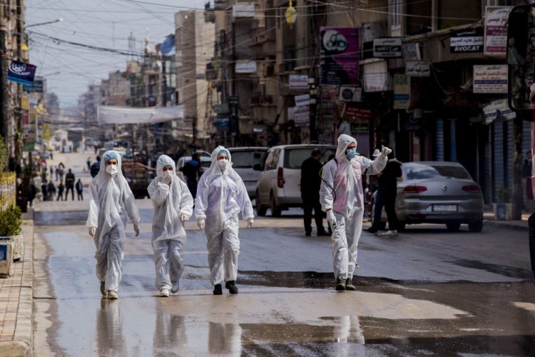Medical workers oversee the disinfection of the streets to prevent the spread of coronavirus in Qamishli, Syria, Tuesday, March 24.