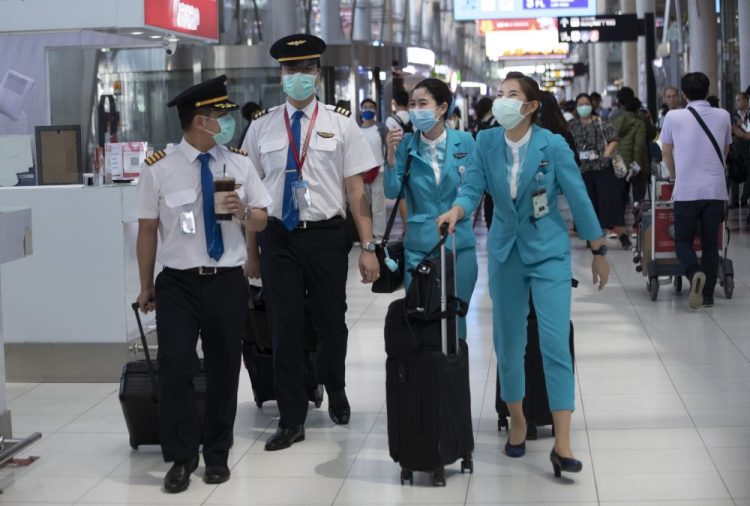 Flight crew wear protective masks as they arrive at the Suvarnabhumi Airport in Bangkok, Thailand, on Wednesday. 