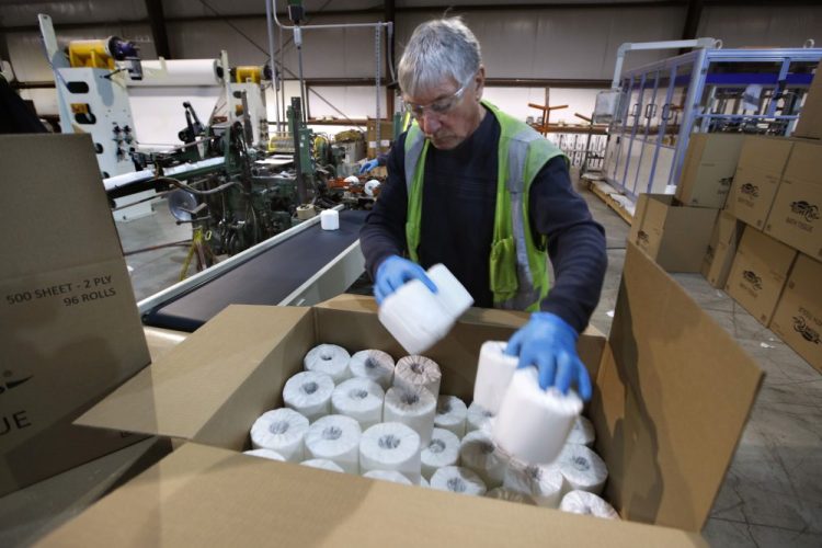 Scott Mitchell fills a box with toilet paper at the Tissue Plus factory, Wednesday, March 18, in Bangor. 