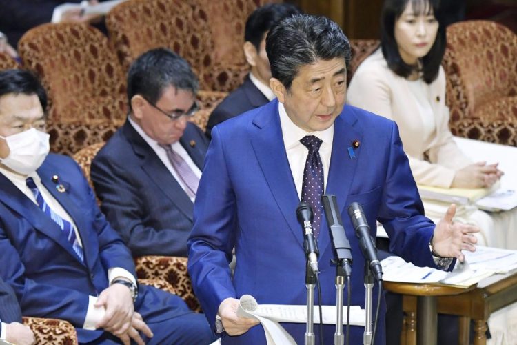 Japan’s Prime Minister Shinzo Abe speaks at a parliamentary session in Tokyo on Monday. Abe said a postponement of the Tokyo Olympics would be unavoidable if the games cannot be held in a complete way because of the coronavirus pandemic.