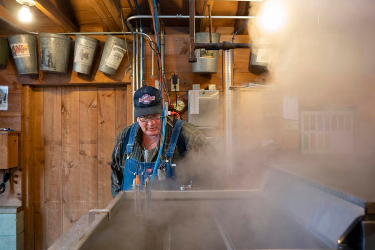 Lyle Merrifield checking the temperature of boiling sap at his farm in 2020.