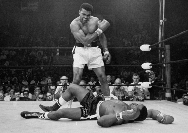 Heavyweight champion Muhammad Ali stands over fallen challenger Sonny Liston shortly after dropping him with a short hard right to the jaw in Lewiston on May 25, 1965. 