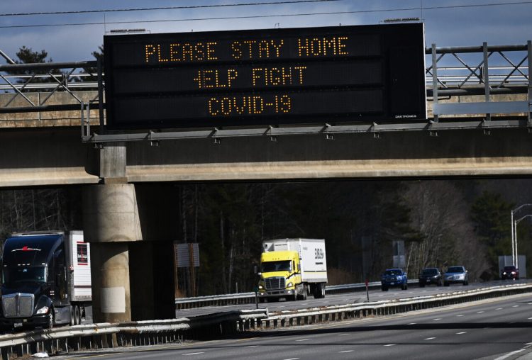 A sign along the Maine Turnpike in Scarborough urges everyone to stay home to help fight COVID-19 on March 31. With fewer cars on the road, some auto insurance providers are starting to offer rate discounts to their customers.