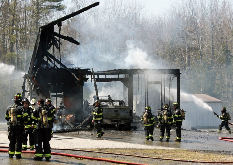 Firefighters douse hot spots Sunday afternoon on Gorham Road in Scarborough where a blaze destroyed a barn. 