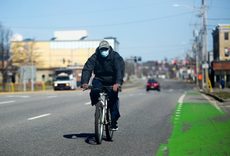 A man rides a bicycle on Forest Avenue in Portland on Wednesday, April 29.