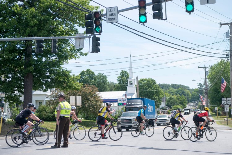 A Somerset Sheriff holds traffic for a massive group of bikers in Norridgewock during the Trek Across Maine ride in 2018. 