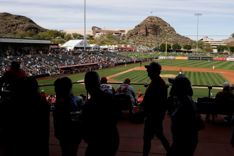 Fans watch a spring training baseball game between the Los Angeles Angels and the San Diego Padres, Thursday in Tempe, Ariz. There have reportedly been discussions between MLB and the players' union about bringing every team to Arizona and starting the season there.