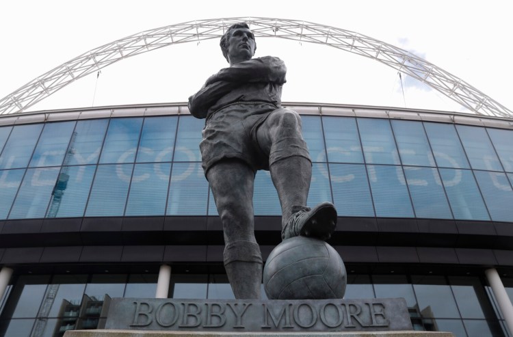The statue of the late England player Bobby Moore outside Wembley Stadium in London, Tuesday, March 17, 2020. UEFA has formally proposed postponing the 2020 European Championship for one year because of the coronavirus outbreak. The Norwegian soccer association says the new tournament dates will be June 11 to July 11. (AP Photo/Alastair Grant)