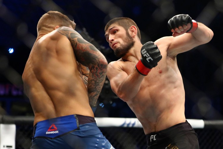 FILE - In this Sept. 7 2019, file photo, Russian UFC fighter Khabib Nurmagomedov, right, fights with UFC fighter Dustin Poirier, of Lafayette, La., during lightweight title mixed martial arts bout at UFC 242 in Yas Mall in Abu Dhabi, United Arab Emirates. Nurmagomedov says he won't leave quarantine in Russia to fight, dealing another blow to UFC President Dana White's determination to hold UFC 249 in two weeks amid the coronavirus pandemic. Nurmagomedov made his announcement Wednesday, April 1, 2020, on Instagram, telling the mixed martial arts world to "take care of yourself and put yourself in my shoes." (AP Photo/Mahmoud Khaled, File)