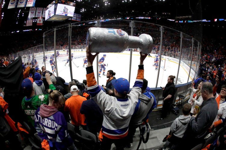 New York Islanders players take the ice as a man holds a makeshift Stanley Cup prior to Game 1 of a first-round playoff series in April 2019. No one knows when or if the NHL will be able to resume play and begin the playoffs.
