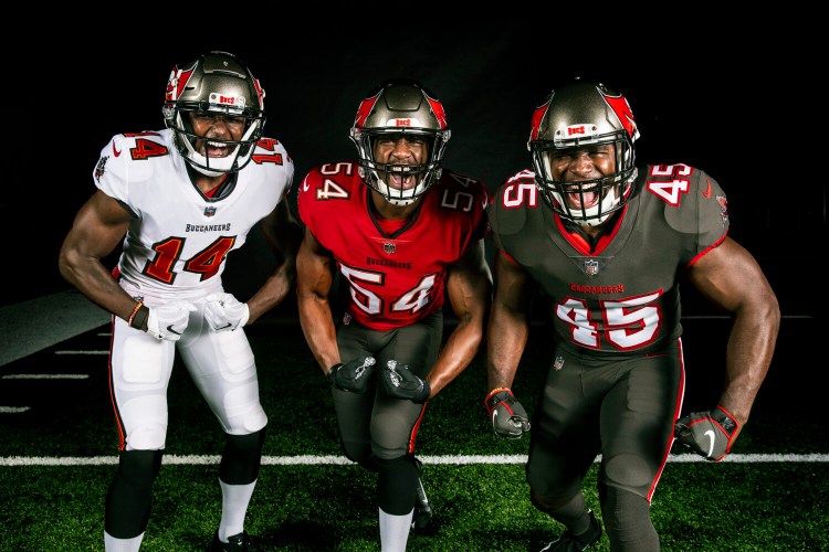 In this handout released by the Tampa Bay Buccaneers, from left, wide receiver Chris Godwin, linebacker Lavonte David, and linebacker Devin White, wear the team's new uniforms.
