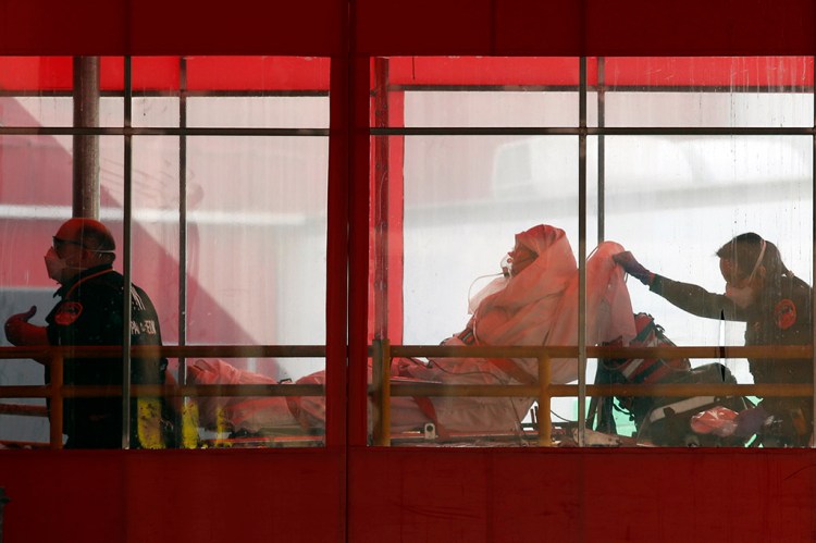 Emergency medical technicians wheel a patient into Elmhurst Hospital Center's emergency room Tuesday in New York City.