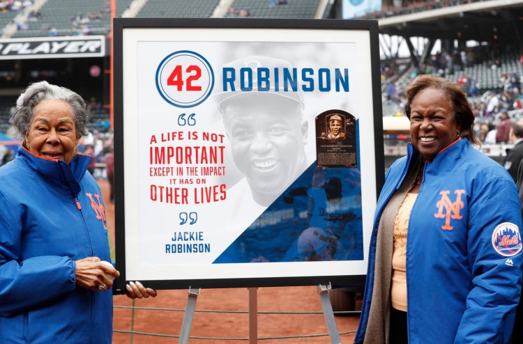 Rachel Robinson, left, widow of Jackie Robinson, and daughter Sharon pose for a photograph with a plaque honoring Jackie on Jackie Robinson Day in 2018. This year, with baseball on hold because of the coronavirus pandemic, Major League Baseball will hold events on television and online to celebrate the day.