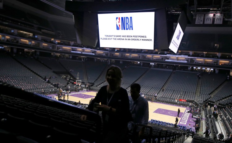 Fans leave the Golden 1 Center  in Sacramento, Calif., after the NBA basketball game between the New Orleans Pelicans and Sacramento Kings was postponed on March 11. NBA facilities will not reopen until May 8, at the earliest, and there will be strict rules when they do.