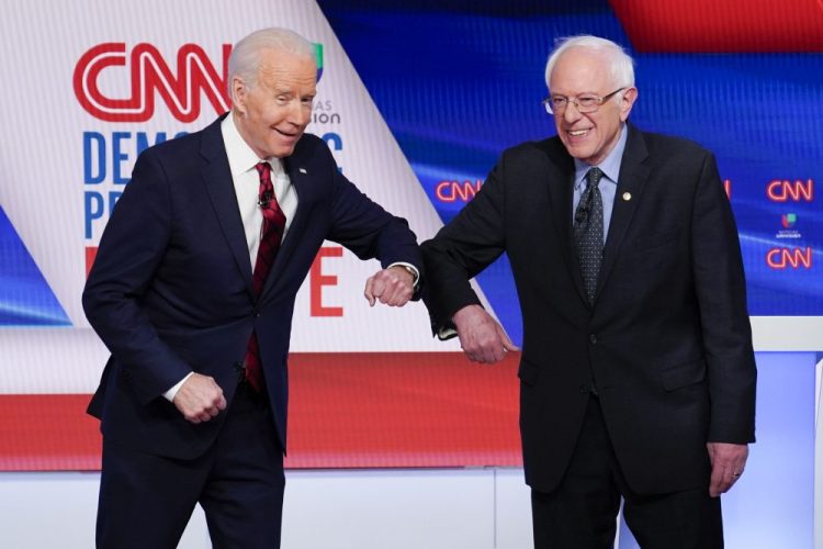 Former Vice President Joe Biden, left, and Sen. Bernie Sanders, I-Vt., right, greet each other before they participate in a Democratic presidential primary debate at CNN Studios in Washington on March 15. Sanders endorsed Biden on Monday.
