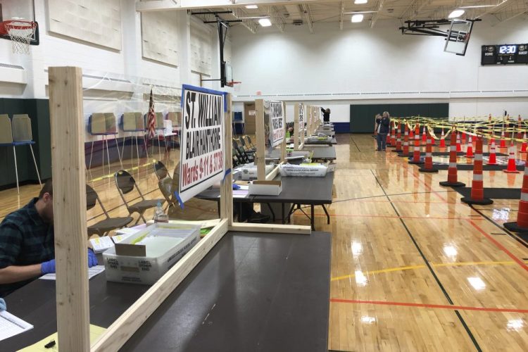 A tables, fitted with protective plexiglass, at the sole polling location for residents of Waukesha, Wis., on Monday. Gov. Tony Evers moved to postpone the state's presidential primary but the state's Supreme Court said the election will proceed. 