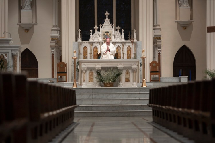 Bishop Robert Deeley,  Bishop of the Roman Catholic Diocese of Portland, delivers Holy Thursday Mass at Cathedral of the Immaculate Conception in April. Starting June 1, Maine parishes will begin offering indoor Masses, with restrictions.