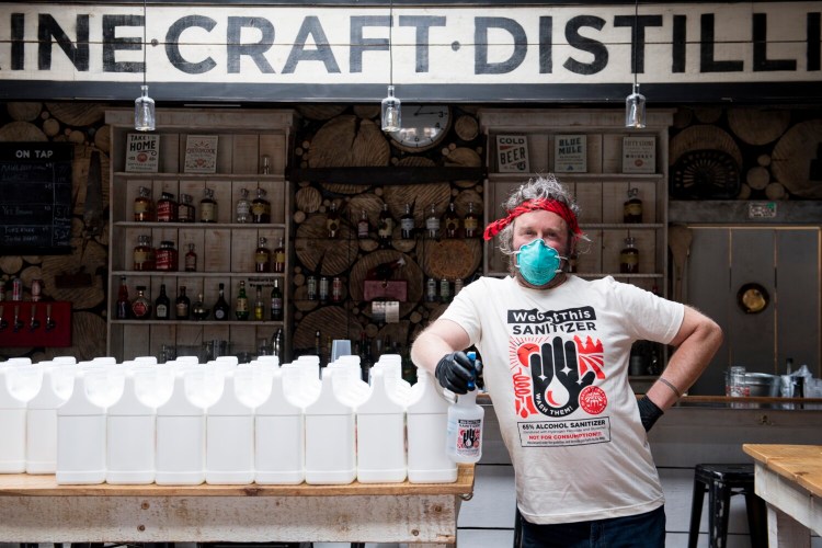 Michael Gatlin, an employee at Maine Craft Distilling in Portland, prepares to distribute more containers of hand sanitizer to those in need.