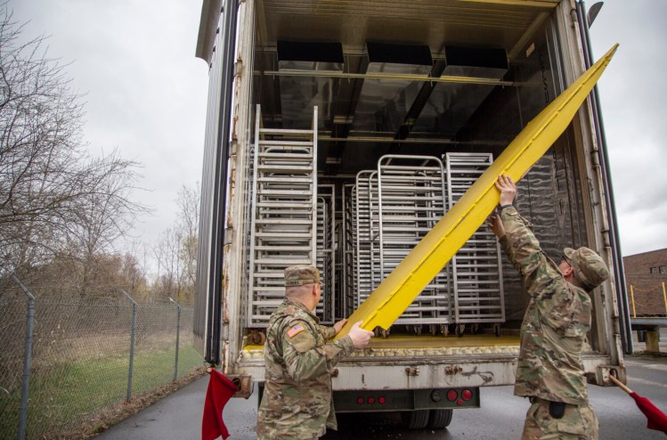 Army National Guardsman Colten Havelka, left, and Zachary Balmes open the back of a shipping container Monday where engineers and professors at Michigan Tech spent a week improvising a giant sanitizer to fight COVID-19. Racks for placing PPE can be seen along with duct work (at top) that will ultimately pump the heat through needed for sterilization. 