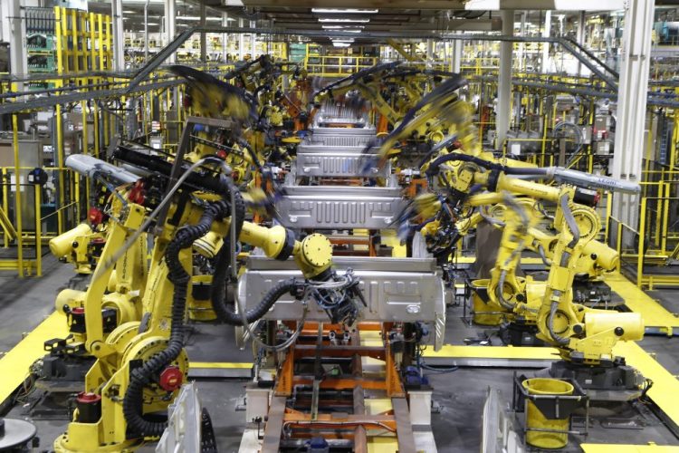 Robots weld the bed of a 2018 Ford F-150 truck on the assembly line at the Ford Rouge assembly plant in Dearborn, Mich. U.S. businesses are edging their way toward figuring out how to bring their employees back to work amid the  pandemic.