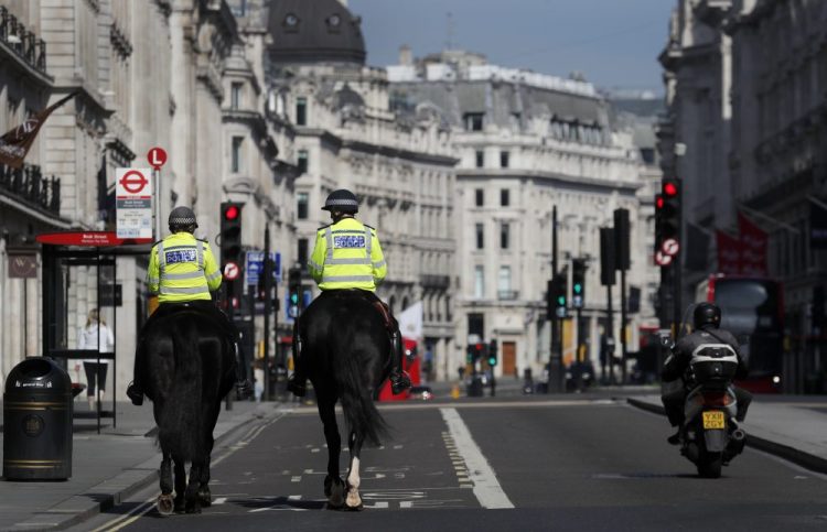 Mounted police officers patrol along a deserted Regent Street in London, as the country is in lockdown to help curb the spread of the coronavirus, Wednesday, April 15.