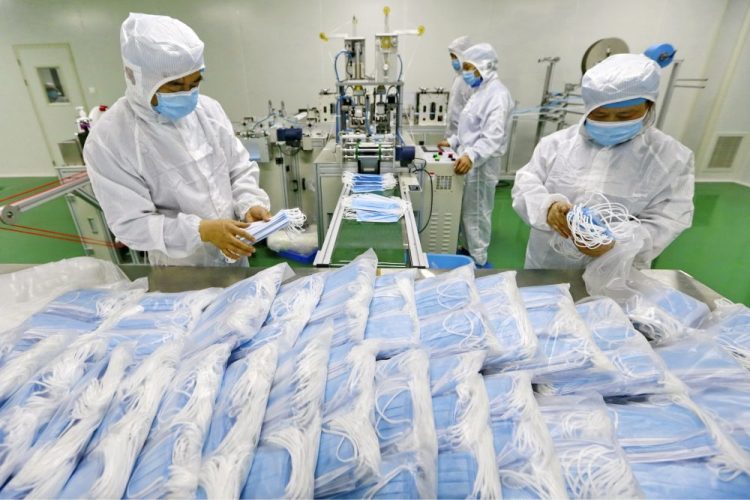 Workers pack surgical masks at a factory Feb. 7 in Suining city in southwest China's Sichuan province.