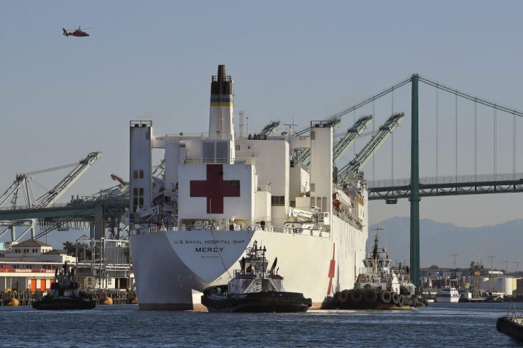 The USNS Mercy hospital ship enters the Port of Los Angeles on March 27. The number of COVID-19 cases among crewmembers of the Mercy has risen to seven while it is docked in the Port of Los Angeles to help serve the region's patients who have not been stricken by the coronavirus. 