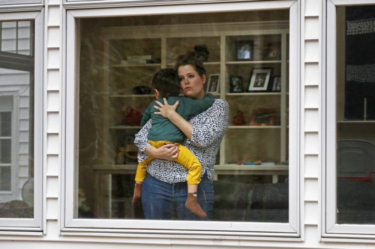 Joy Engel holds her son Wednesday at her home in Cape Elizabeth. Engel, who is pregnant, and her husband, Dr. Ben Hagopian, who works at a family practice and an urgent care clinic, decided to isolate themselves from each since the coronavirus outbreak. 
