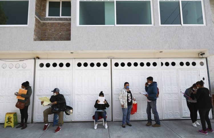 People, maintaining a safe distance between each other, wait outside the national health workers union on Tuesday in Mexico City to apply for job. Six hundred people in Mexico have died of COVID-19, according to authorities.