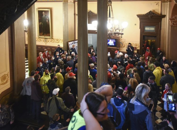 Protesters gather outside the entrance of the Michigan House of Representatives in Lansing, Mich. on Thursday. 