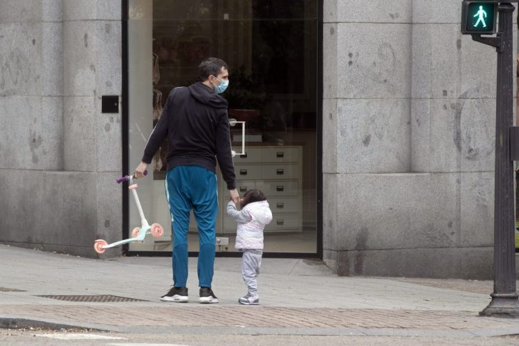 A man takes a young girl for a walk in Madrid, Spain, on Sunday. Children under 14 years old are finally allowed to take walks with a parent, ending six weeks of compete seclusion due to the coronavirus outbreak. 