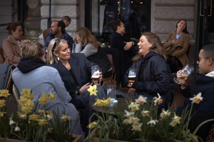 People chat and drink outside a bar on Wednesday in Stockholm, Sweden. Sweden is pursuing relatively liberal policies to fight the pandemic, even though there has been a sharp spike in deaths. Most restaurants and businesses are still open.