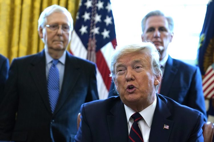 President Trump signs a stimulus package last month. Looking on are Senate Majority Leader Mitch McConnell, R-Ky., left, and House Minority Leader Kevin McCarthy of Calif. 