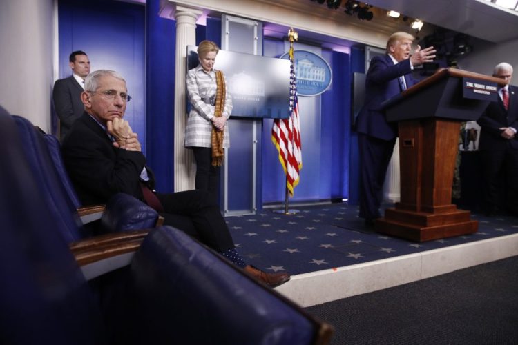 Dr. Anthony Fauci, director of the National Institute of Allergy and Infectious Diseases, left, listens as President Trump speaks during a coronavirus task force briefing at the White House in April in Washington. From left, Fauci, Dr. Deborah Birx, White House coronavirus response coordinator, Trump and Vice President Mike Pence. Pence said Tuesday that the task force could disband by early June, but no decision has been made.