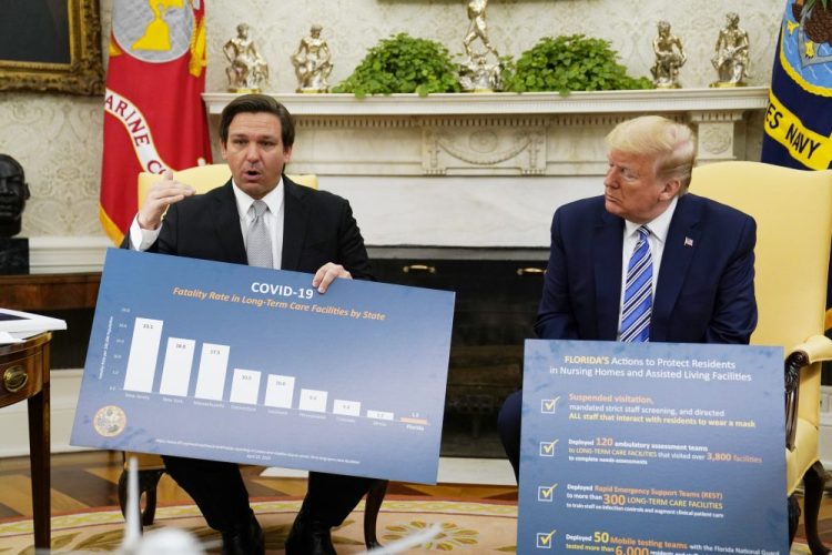 President Trump hosts a meeting with Gov. Ron DeSantis, R-Fla., in the Oval Office on Tuesday. Asked why he closed his state later than others did, DeSantis contrasted Florida’s “tailored” and “measured” approach with “draconian” measures in other states.