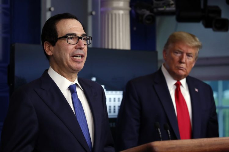 President Trump listens as Treasury Secretary Steven Mnuchin speaks about the coronavirus April 13 in the James Brady Press Briefing Room at the White House in Washington. The Trump administration and Congress are nearing an agreement as early as Sunday on a $400-plus billion aid package to boost a small-business loan program that has run out of money and add funds for hospitals and COVID-19 testing.