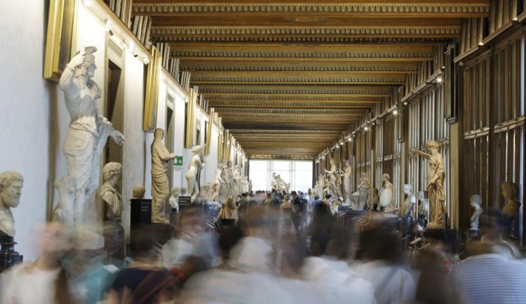 In this Aug. 6, 2019 file photo, visitors walk through corridors of the Uffizi Gallery Museum, in Florence, Italy. 