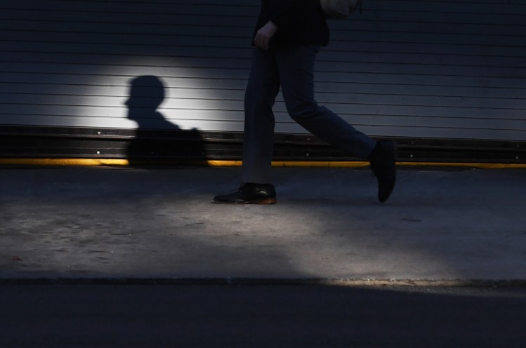 A pedestrian casts a shadow along 11th Street NW during a quiet and nearly desolate morning rush hour on Thursday in Washington, D.C. Mental health experts say it's normal for people to be anxious and worried amid a highly disruptive health emergency that's shot through with uncertainties.