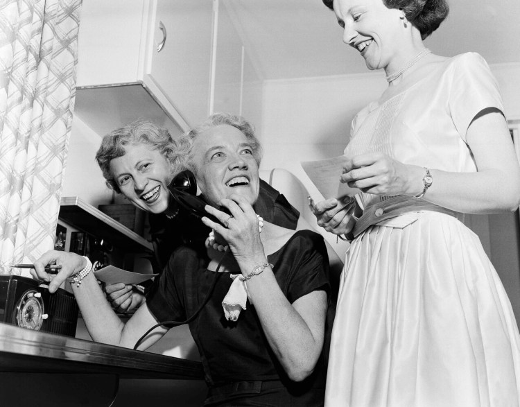 Sen. Margaret Chase Smith looks up to call out good news to friends in the kitchen of her home in Skowhegan on June 21, 1954, as returns of the primary gave her a wide lead for the Republican senatorial nomination. On her left is Blanche Hudon and on her right is Helen Wing.