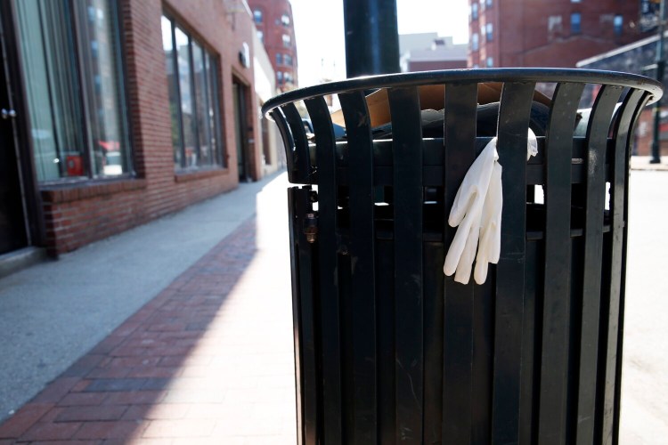 A protective glove clings to a trash barrel on Congress Street in Portland.